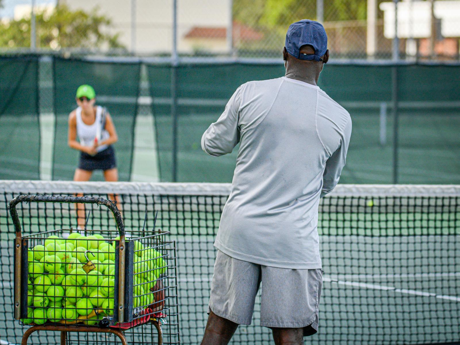 A coach running a tennis lesson on court